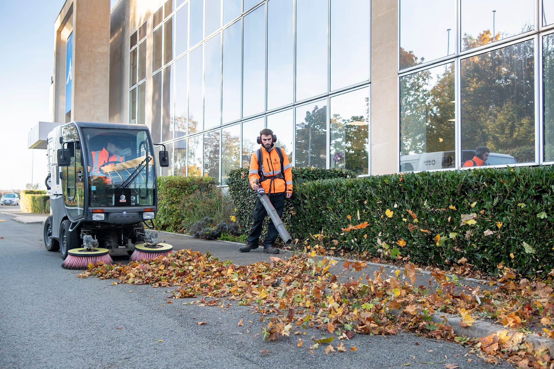 Grounds care: blowing leaves and sweeping along a building.