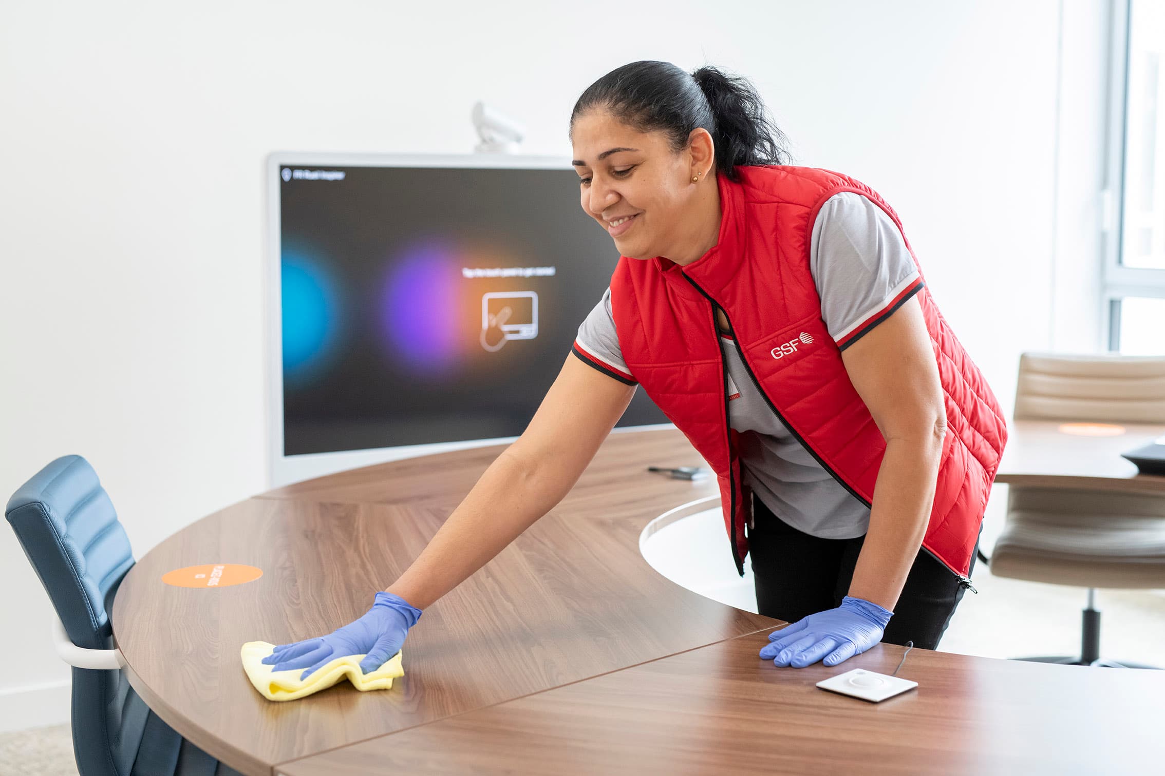 GSF team member wiping a meeting table in an office.