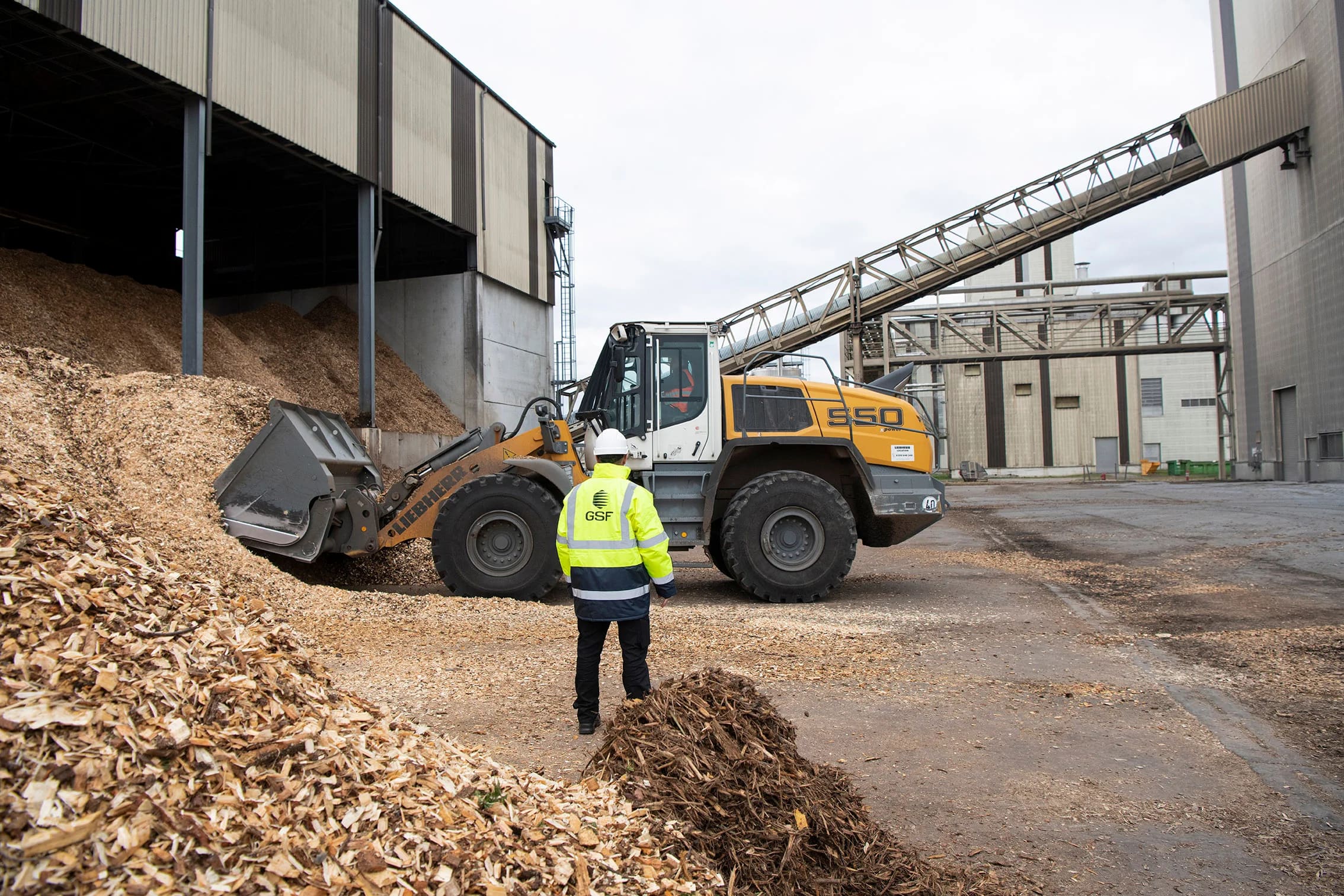 Opération de chargement de biomasse avec engins industriels — imagerie opérationnelle générique.
